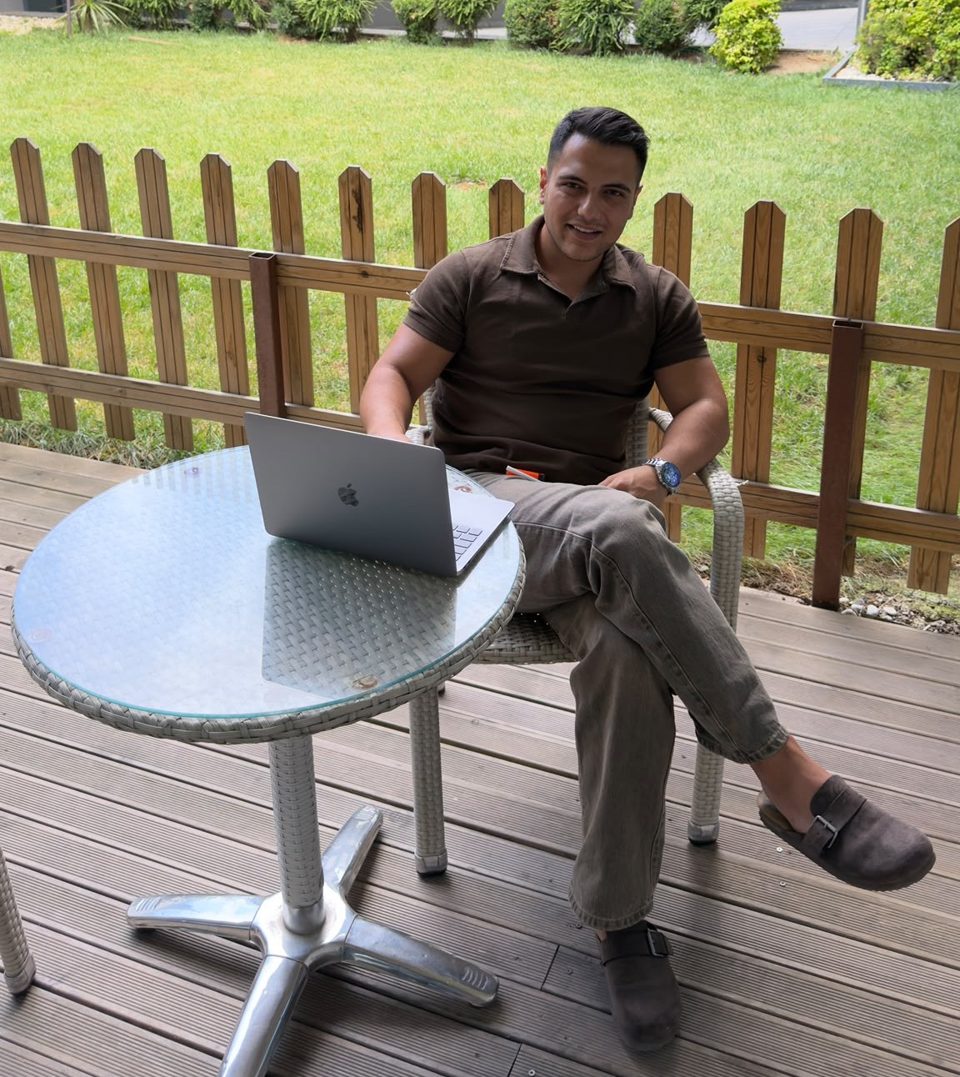 Musa Üçüncü, founder of Z6BN, working on a laptop on a garden terrace